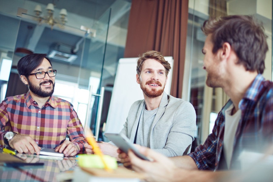 Three colleagues talking in a relaxed meeting
